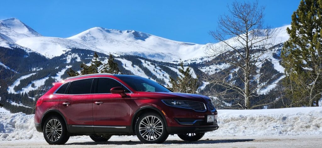 Lincoln MKX AWD rental SUV parked with Breckenridge ski slopes behind
