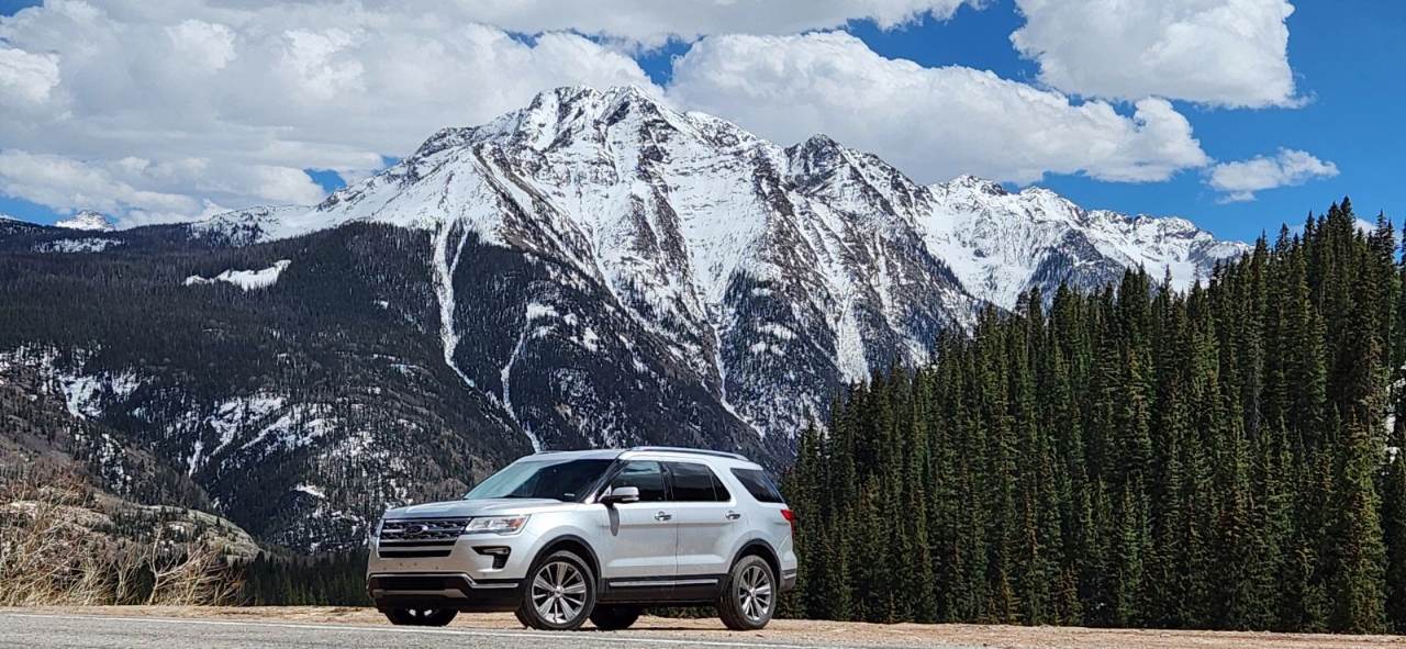Summit Rental Car 2018 silver AWD Ford Explorer with snow tires on a mountain road near Breckenridge, Colorado